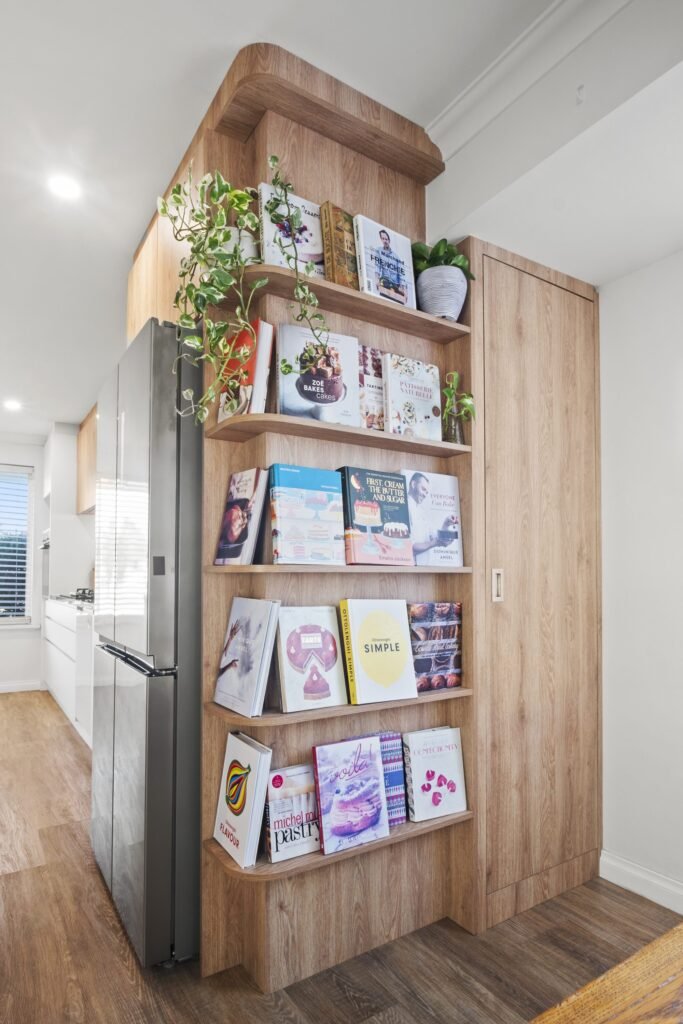 Cookbook shelves built into the end of the fridge cabinet