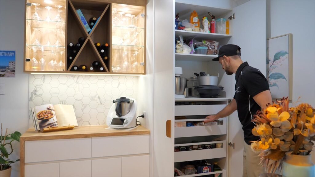 Vincent in the everyday pantry beside the bar nook: two doors, full-width inner drawers behind them