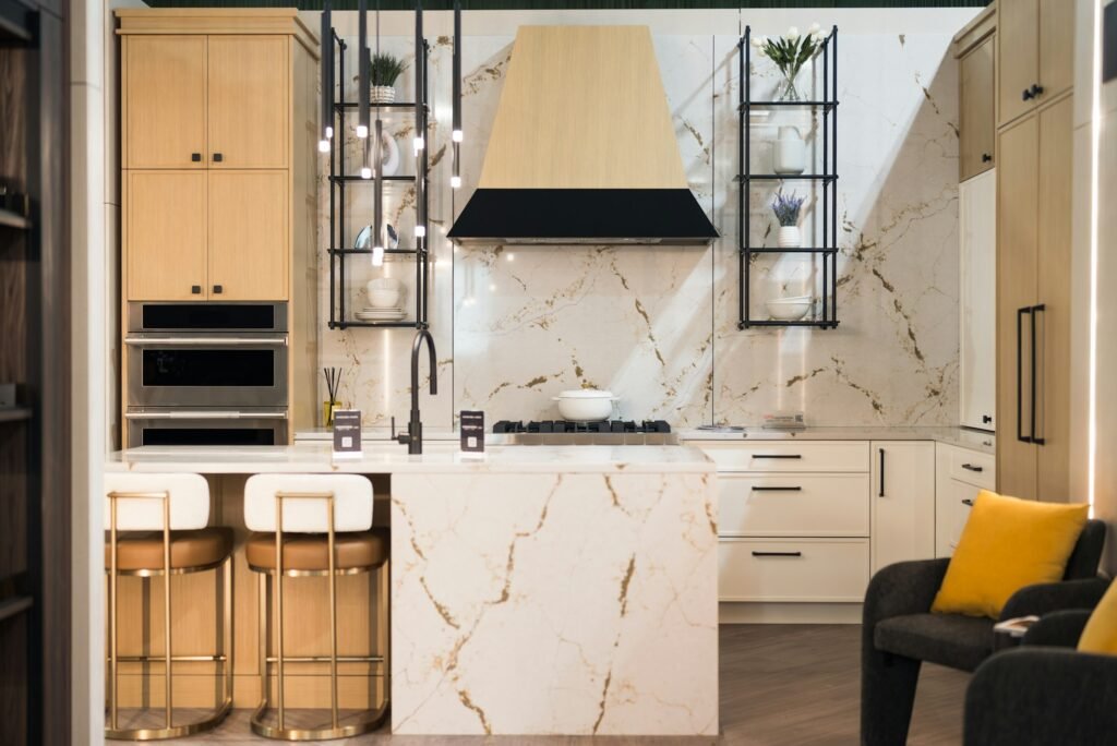 Marble waterfall island with brass and leather bar stools