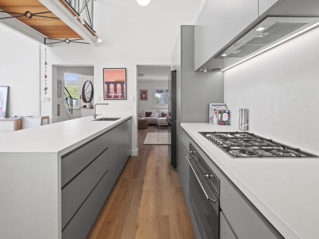Down the galley toward the living room, the mezzanine walkway overhead