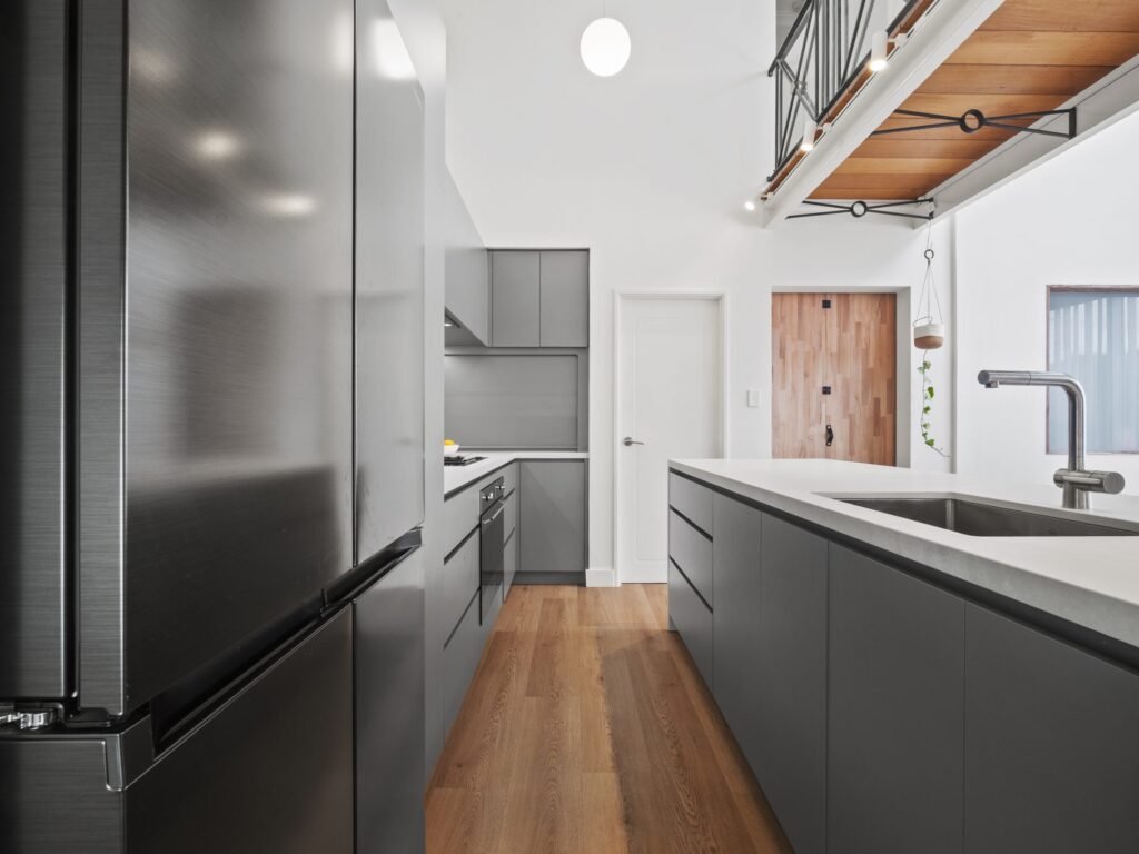 Past the black fridge to the timber front door
