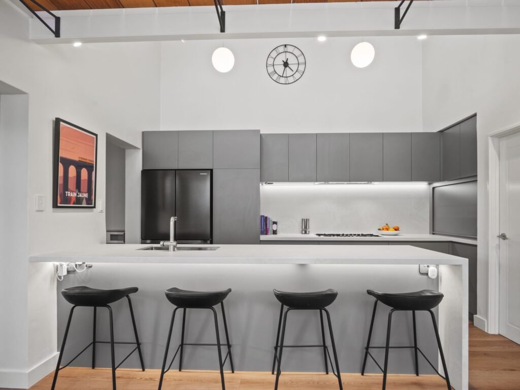 From the living area: the peninsula, four stools, the LED line under the overheads