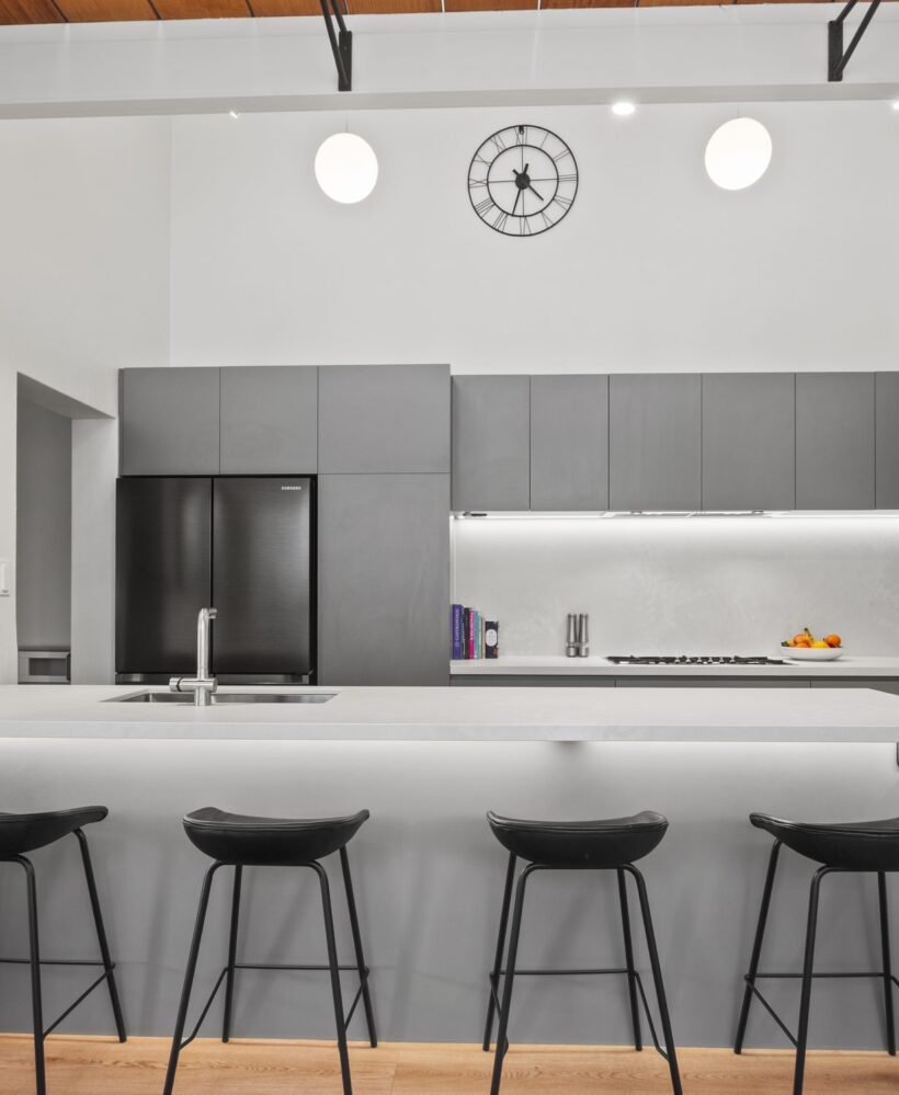 From the living area: the peninsula, four stools, the LED line under the overheads