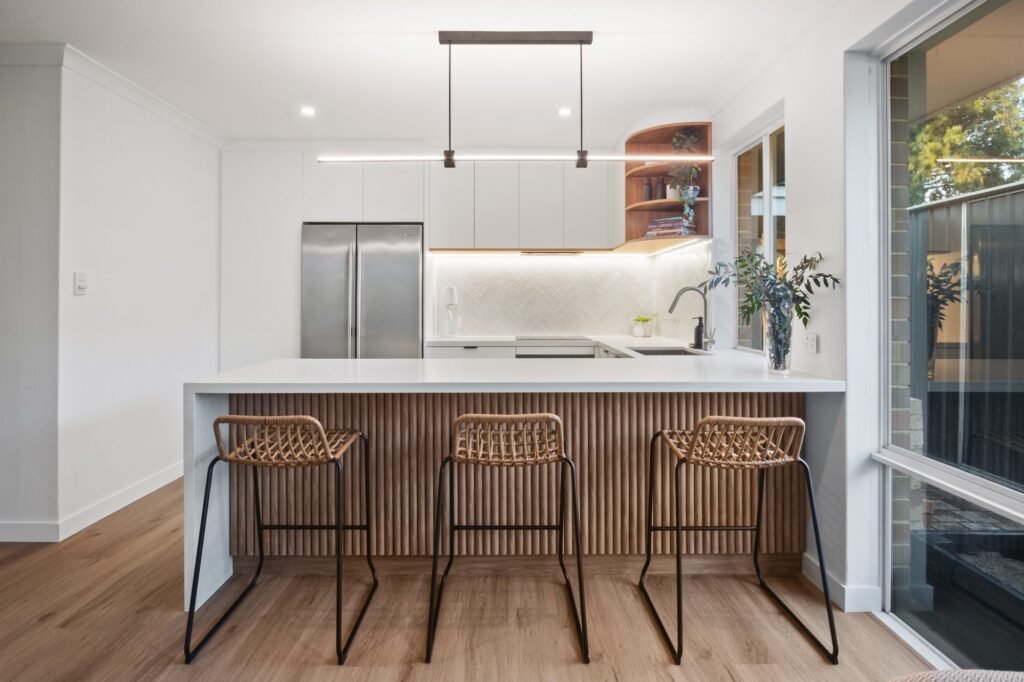 The peninsula front: half-round battens, cane stools, the white stone waterfall end